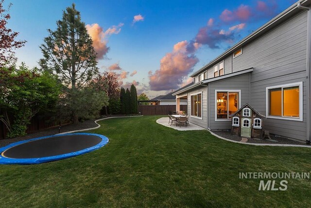 view of yard with fence, a patio area, and a trampoline