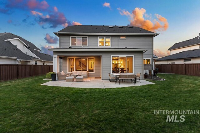 back of house with an outdoor living space, a lawn, and a fenced backyard