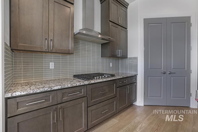 2252 Detweiler Pl, Twin Falls, ID 83301 - kitchen featuring stainless steel gas stovetop, light wood-style floors, wall chimney range hood, light stone countertops, and dark brown cabinets