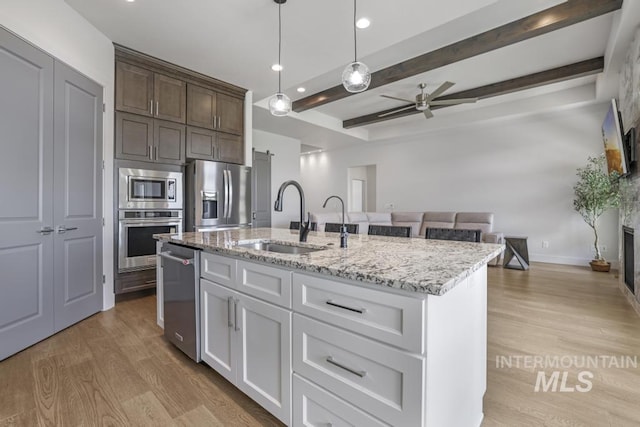 2252 Detweiler Pl, Twin Falls, ID 83301 - kitchen with light wood-style flooring, light stone countertops, stainless steel appliances, a ceiling fan, and a sink