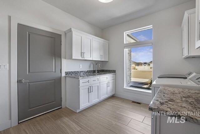 2252 Detweiler Pl, Twin Falls, ID 83301 - kitchen featuring separate washer and dryer, white cabinets, light wood-style floors, and a sink