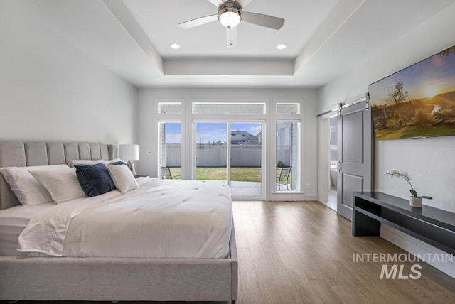 2252 Detweiler Pl, Twin Falls, ID 83301 - bedroom with a tray ceiling, recessed lighting, access to outside, a barn door, and wood finished floors