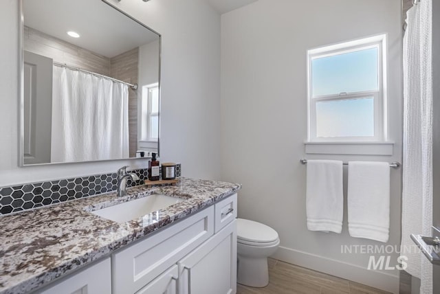 2252 Detweiler Pl, Twin Falls, ID 83301 - full bath featuring toilet, curtained shower, vanity, wood finished floors, and baseboards