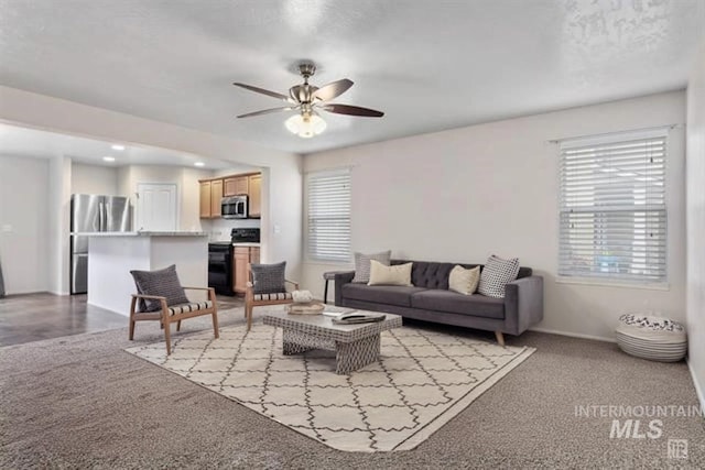 living room featuring ceiling fan and a healthy amount of sunlight