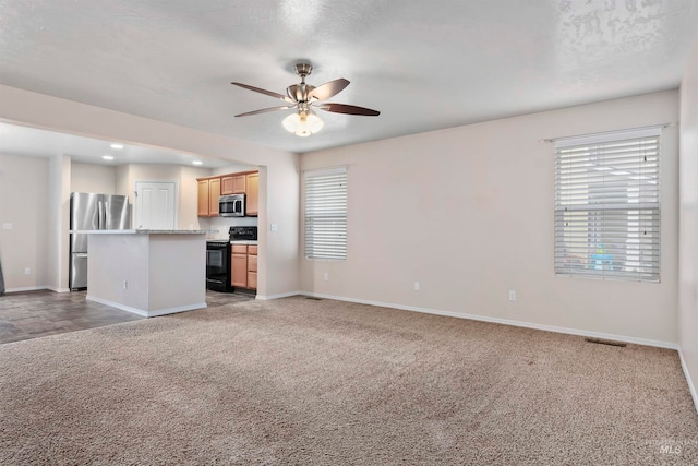 unfurnished living room with ceiling fan, light carpet, and a textured ceiling