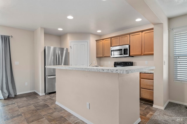 kitchen with light brown cabinetry and appliances with stainless steel finishes