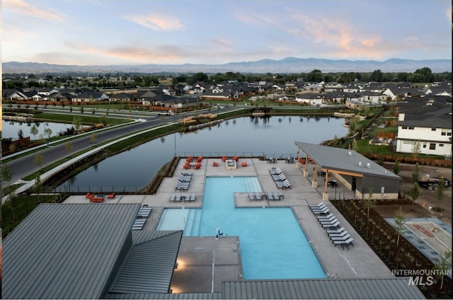 aerial perspective of suburban area with a pool and a water and mountain view