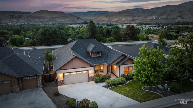 3924 E Forked Deer St, Boise, ID 83716 - craftsman-style home with stone siding, concrete driveway, an attached garage, board and batten siding, and a shingled roof
