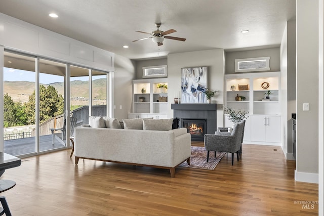 3924 E Forked Deer St, Boise, ID 83716 - living room with ceiling fan, a tile fireplace, wood finished floors, a mountain view, and recessed lighting