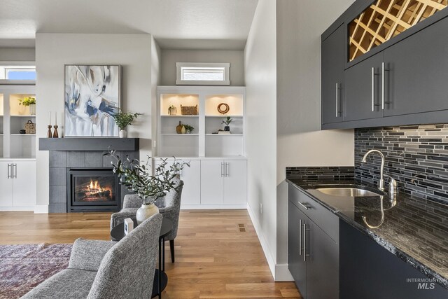 3924 E Forked Deer St, Boise, ID 83716 - bar area featuring a tile fireplace, light wood-style flooring, and tasteful backsplash
