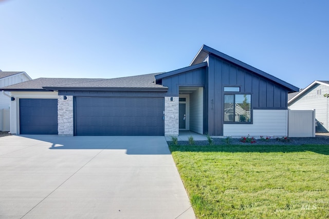 view of front facade with a front lawn, driveway, board and batten siding, a shingled roof, and a garage