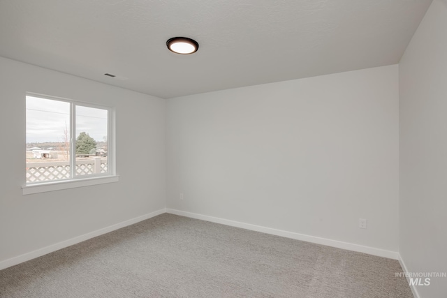 empty room with baseboards and carpet flooring