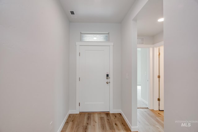 entryway featuring light wood finished floors, visible vents, and baseboards