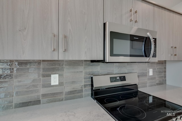 kitchen with decorative backsplash, light brown cabinets, stainless steel appliances, and modern cabinets