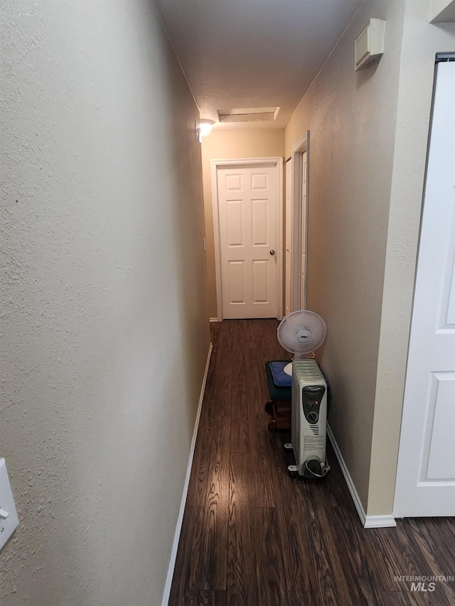 hall featuring wood finished floors, attic access, and baseboards