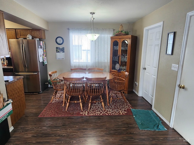 dining space featuring dark wood-type flooring and baseboards