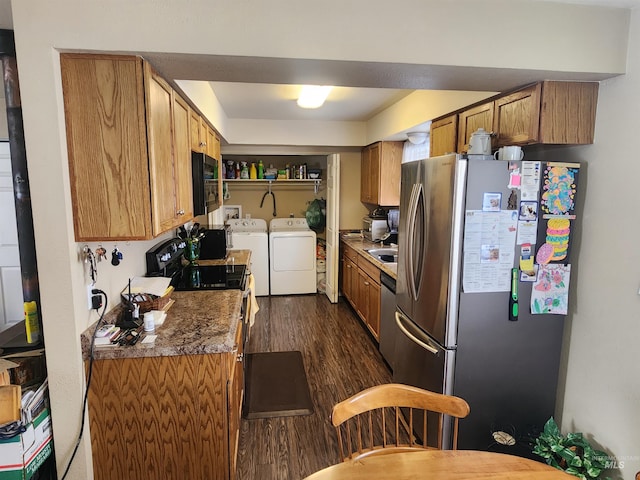 kitchen featuring dark wood-style floors, appliances with stainless steel finishes, brown cabinetry, a sink, and washer and dryer