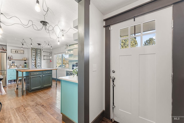 kitchen featuring light hardwood / wood-style floors, stainless steel fridge, and tasteful backsplash