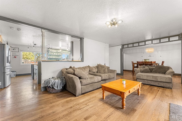 living room featuring a textured ceiling, a notable chandelier, and hardwood / wood-style floors