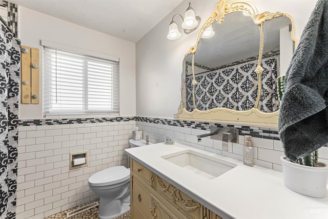 bathroom with tile walls, a textured ceiling, vanity, and toilet