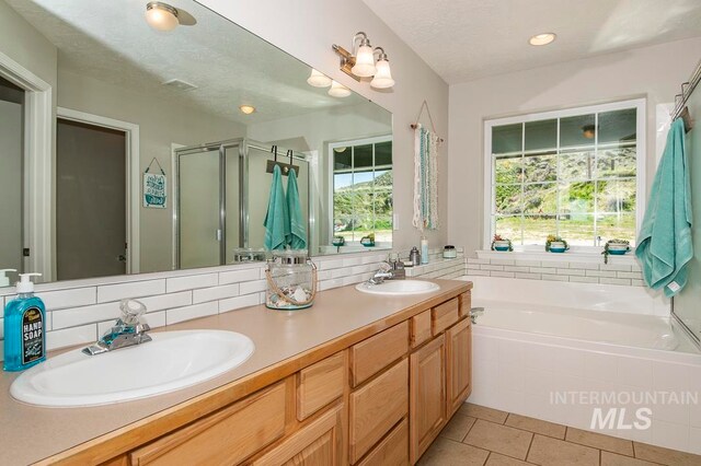 bathroom with dual vanity, separate shower and tub, backsplash, a textured ceiling, and tile floors