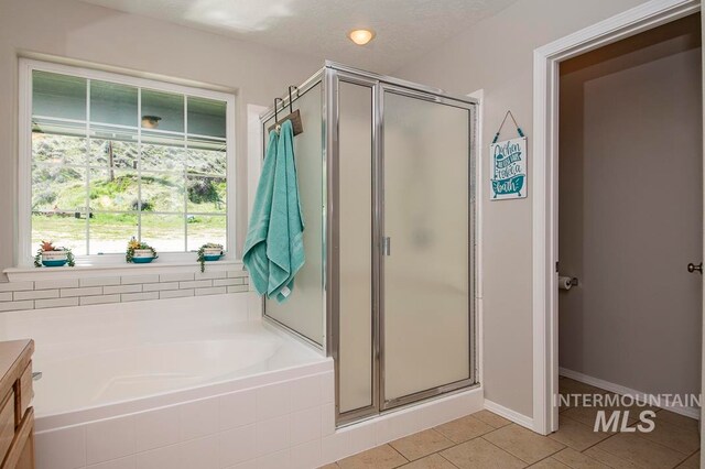 bathroom featuring tile floors, a textured ceiling, vanity, and independent shower and bath