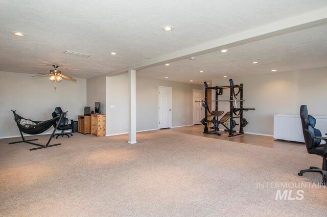 carpeted office featuring ceiling fan and a textured ceiling