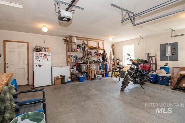 garage featuring white refrigerator and a garage door opener