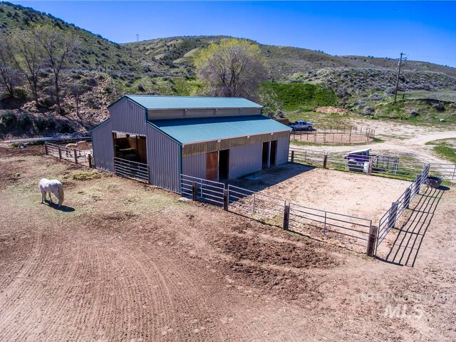 exterior space featuring a rural view, a mountain view, and an outdoor structure