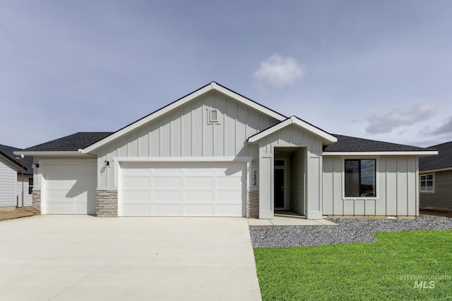 5372 E Burnte Peak St, Nampa, ID 83687 - view of front of home with board and batten siding, an attached garage, driveway, roof with shingles, and a front yard