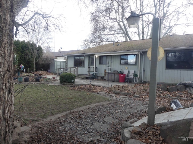 back of property with a patio area and a lawn