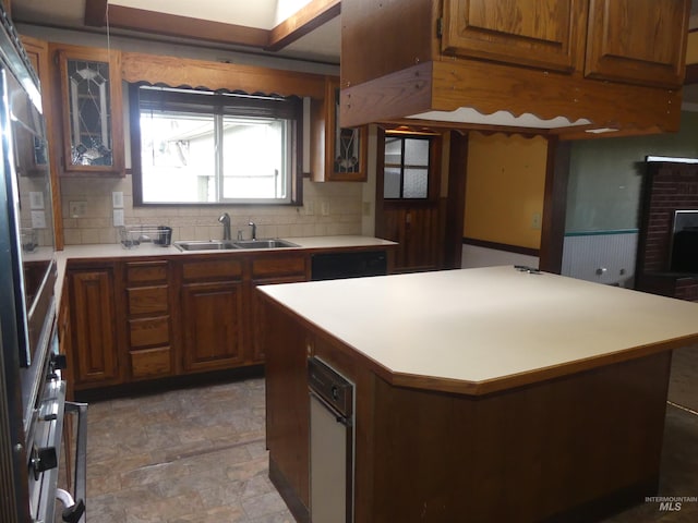 kitchen with a center island, sink, stainless steel oven, and backsplash