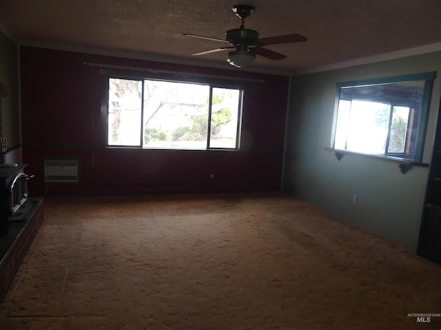 spare room featuring a wealth of natural light, a wall mounted AC, carpet floors, and a wood stove