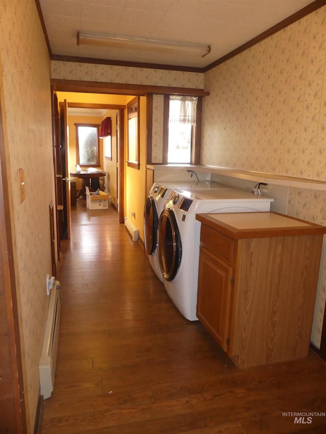 laundry area with crown molding, cabinets, wood-type flooring, a baseboard radiator, and washer and clothes dryer