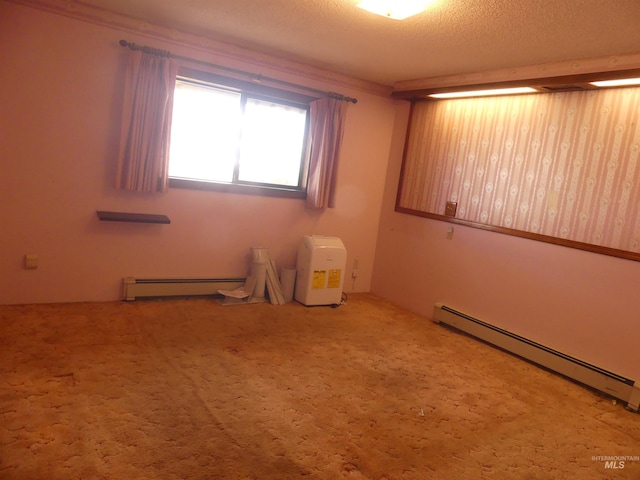 spare room with baseboard heating, carpet, and a textured ceiling