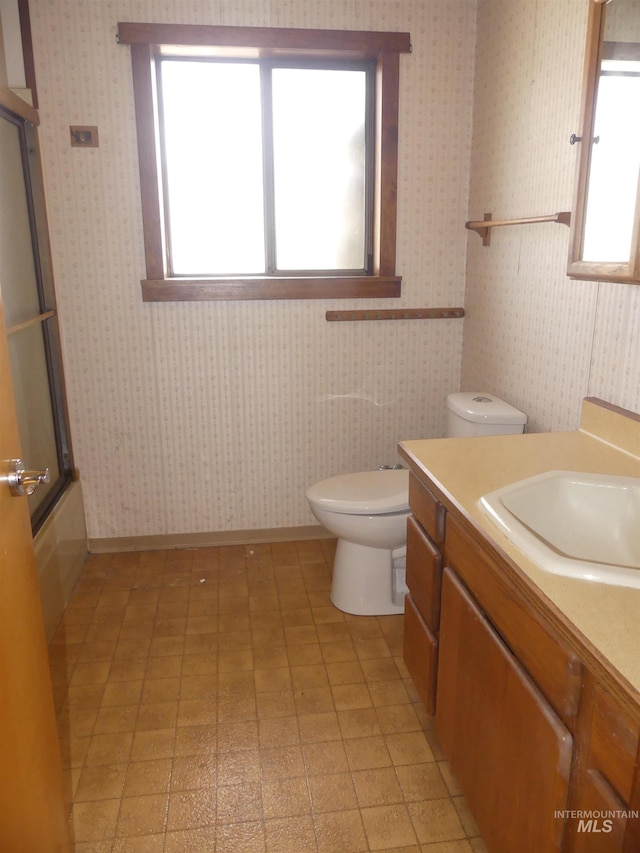 full bathroom with vanity, combined bath / shower with glass door, and toilet