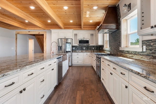 kitchen featuring white cabinets, custom range hood, appliances with stainless steel finishes, and wooden ceiling