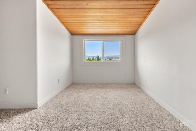 empty room with lofted ceiling, carpet floors, and wooden ceiling