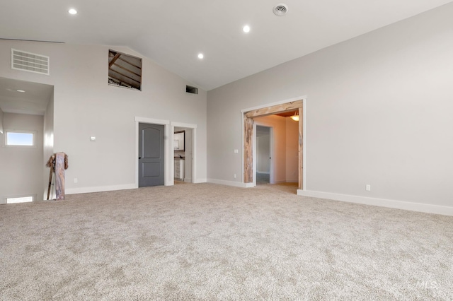 unfurnished bedroom featuring light colored carpet and high vaulted ceiling