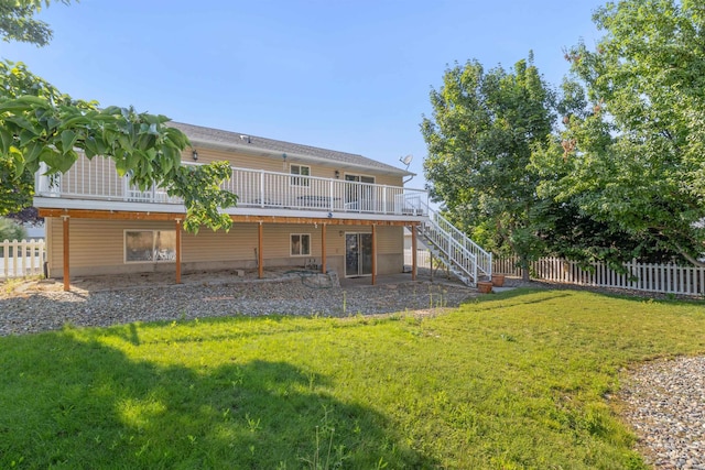 back of property with a lawn, stairway, a wooden deck, and fence