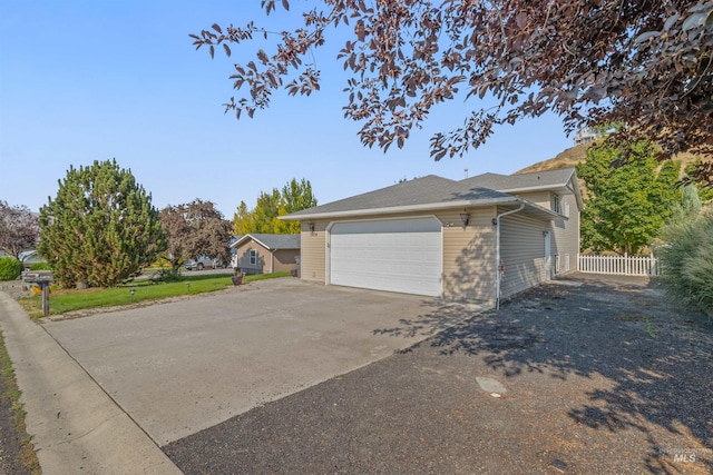 view of home's exterior featuring driveway and fence