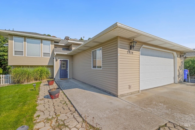 view of front facade with driveway, an attached garage, and a front yard