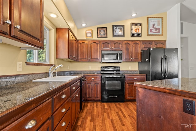 kitchen featuring lofted ceiling, tile countertops, dark wood-type flooring, black appliances, and a sink