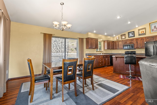 dining room featuring a chandelier, recessed lighting, vaulted ceiling, and dark wood finished floors