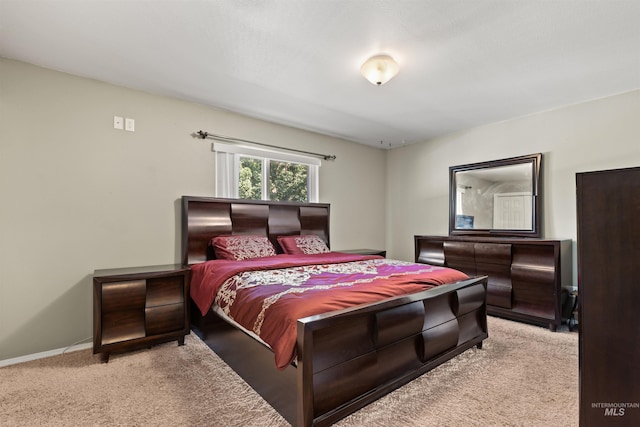 bedroom featuring light carpet and baseboards