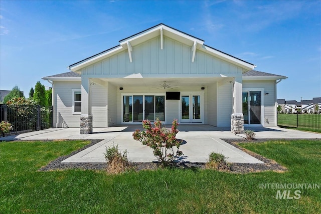 back of property featuring ceiling fan, a lawn, and a patio area