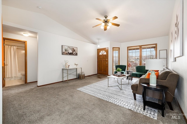 living area featuring lofted ceiling, baseboards, a ceiling fan, and carpet flooring