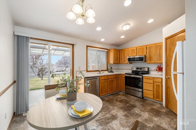 kitchen with vaulted ceiling, stainless steel appliances, light countertops, a sink, and recessed lighting