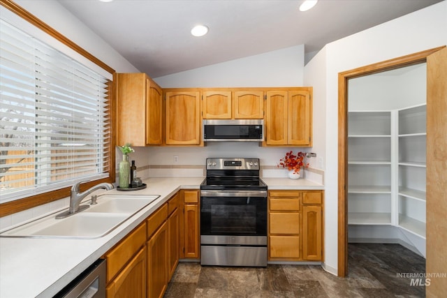 kitchen featuring recessed lighting, a sink, vaulted ceiling, light countertops, and appliances with stainless steel finishes