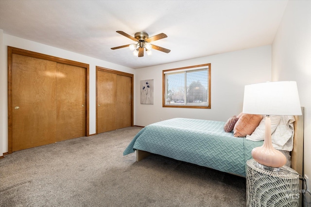 bedroom with carpet floors, a ceiling fan, and multiple closets